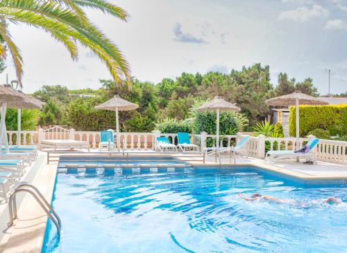 埃斯普霍斯Roquetes Rooms - Formentera Break的一个带椅子和遮阳伞的游泳池