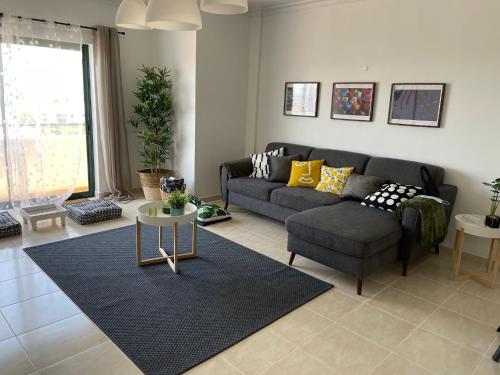 法鲁OmniaX Apartment的客厅配有沙发和桌子