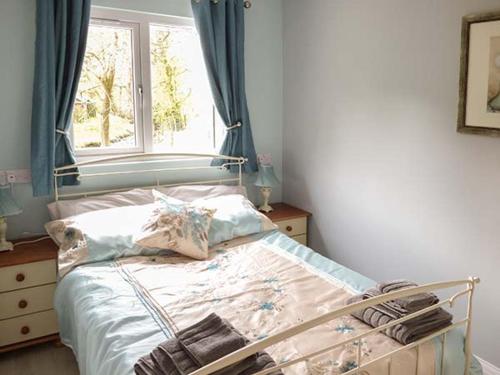 ScortonPark Brook Retreat的一间卧室设有一张带窗户和窗户的床。