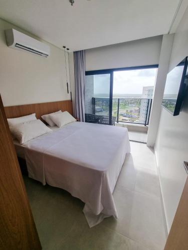 萨利诺波利斯SALINAS PREMIUM RESORT的卧室设有白色的床和大窗户