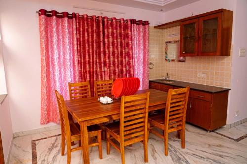 维沙卡帕特南Blue stone homestay guesthouse的厨房配有木制用餐室的桌椅
