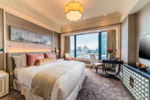 胡志明市卡拉维拉西贡酒店的一间卧室设有一张大床和一个大窗户