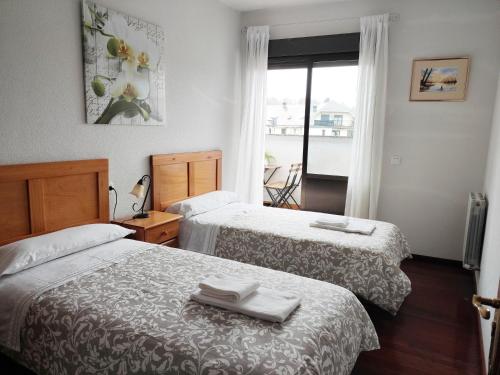 埃尔蓬特DÚPLEX SANABRIA的酒店客房设有两张床和窗户。