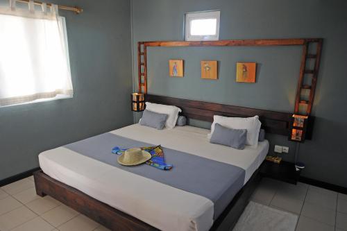 Rodrigues Island派克斯山林小屋的一间卧室,配有一张床,上面有帽子