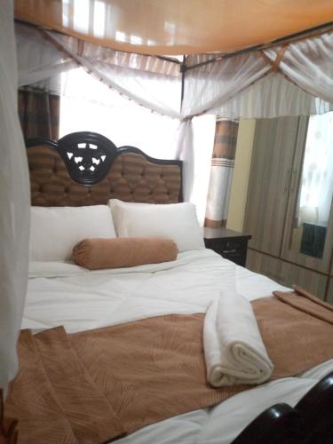 基苏木Levans Lounge的卧室配有一张带白色床单和枕头的大床。
