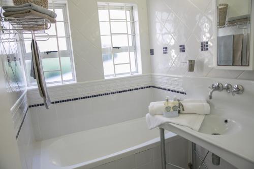 巴利托Sunshowers Ballito的白色的浴室设有水槽和浴缸。