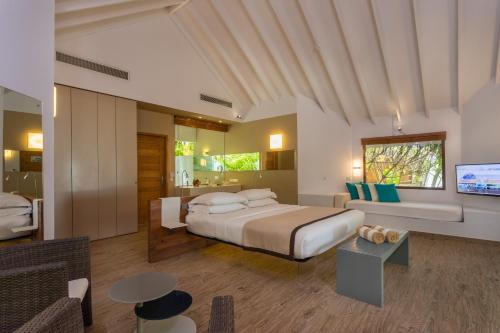 拉薇亚妮环礁Cocoon Maldives - All Inclusive的一间卧室配有一张特大号床和一台电视