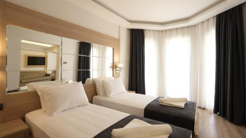 费特希耶Alesta Seaside Residence的酒店客房,设有两张床和镜子