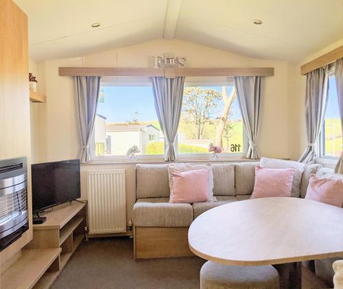 纽基4 Berth Couples and Family Caravan in Beautiful Newquay Bay Resort的客厅配有沙发和桌子