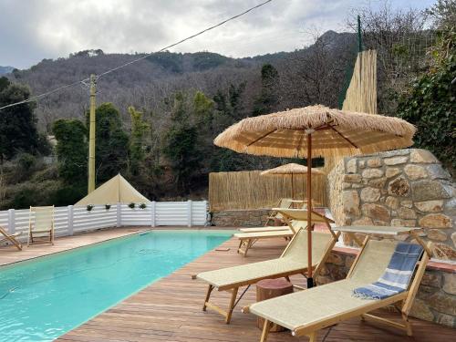 马尔恰纳Valle dei Mulini B&B的游泳池旁的游泳池配有椅子和遮阳伞