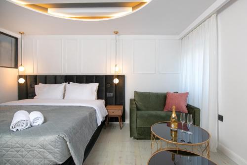 科孚镇Kantoni Luxury Suites的一间卧室配有一张床、一张沙发和一张桌子