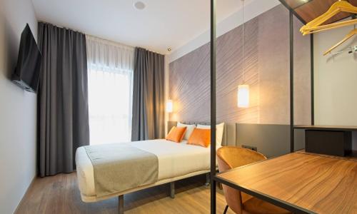 马德里DWO Yuste Alcalá的酒店客房配有一张床铺和一张桌子。
