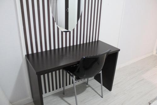 胡米利亚Hostal Fuente del Pino的一张带椅子和镜子的黑色书桌