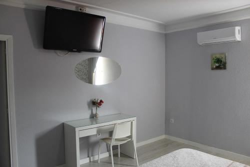 胡米利亚Hostal Fuente del Pino的白色的客房设有一张桌子和一台墙上的电视