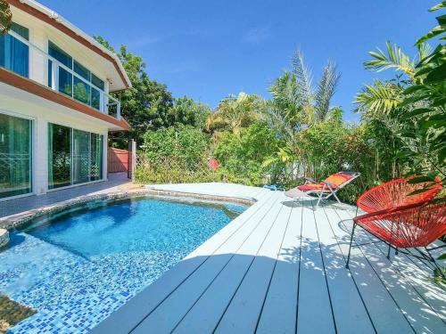 班佩Tina's Living Paradise - Guesthouses with private pool的一个带椅子的游泳池以及一座房子