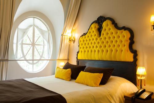 布宜诺斯艾利斯布宜诺斯艾利斯伦兹沃斯酒店的一间卧室配有一张带黄色床头板的大床