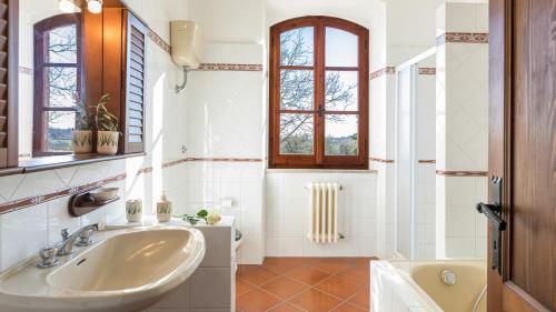 奥维多CASALE LE TRE QUERCE 8&1, Emma Villas的一间带水槽和浴缸的浴室以及窗户。