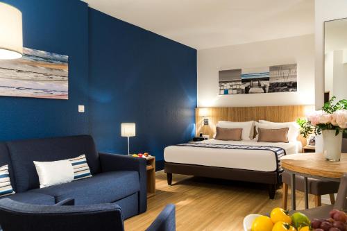 戛纳Citadines Croisette Cannes的酒店客房,配有床和沙发