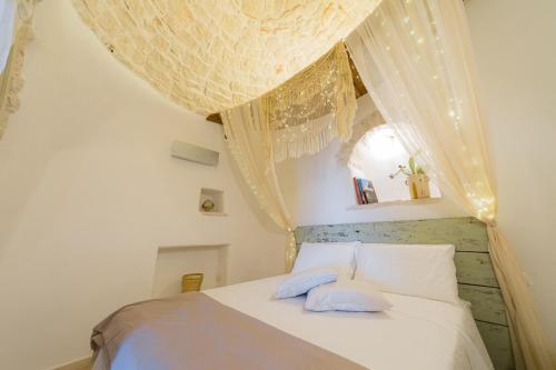阿尔贝罗贝洛Trullo Love的一间卧室配有白色的床和2个蓝色枕头
