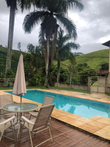 IbitiramaPousada Viva的一个带桌椅的庭院和一个游泳池