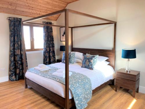 ForgandennyPheasant Lodge with Hot Tub的一间卧室设有四柱床和窗户。
