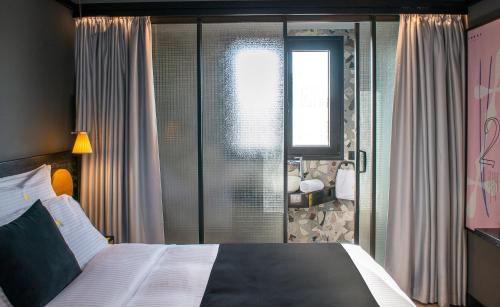 海若克利欧3 Pines Design Living的一间卧室设有一张大床和一个窗户。