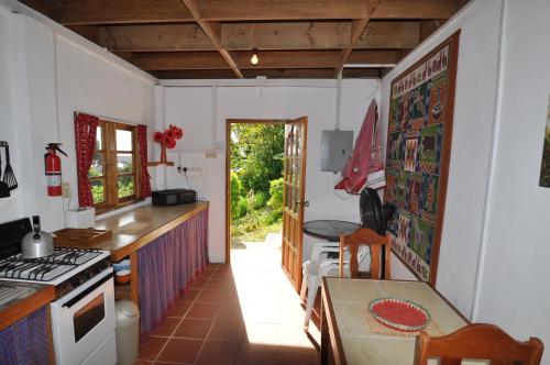 Castara卡斯塔拉度假屋的厨房配有桌子和炉灶。 顶部烤箱