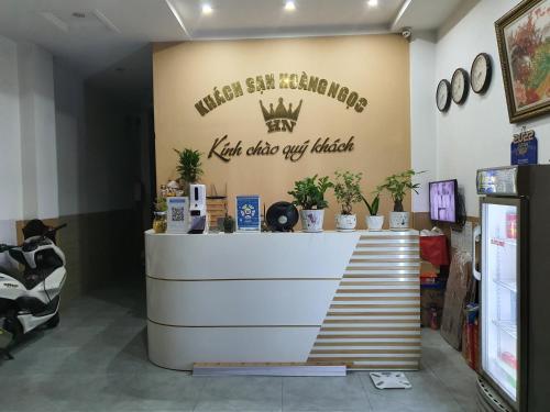 Dĩ AnHoang Ngoc Hotel的墙上有植物柜台的商店