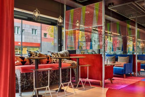 斯德哥尔摩斯德哥尔摩创造者旅舍的餐厅设有红色和蓝色的椅子和桌子