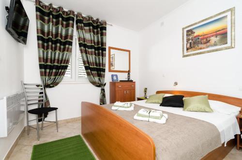 杜布罗夫尼克卡佩里卡客房和公寓的一间卧室配有一张床,上面有两条毛巾
