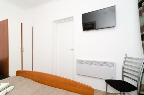 杜布罗夫尼克卡佩里卡客房和公寓的一间卧室配有一张床,墙上配有电视