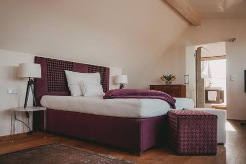 加姆利茨Winkel Art Hotel的一间卧室配有一张大床和紫色床头板