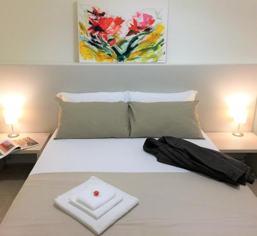 卢切拉Residenza DaMa的一间卧室,配有一张带两盏灯和盘子的床
