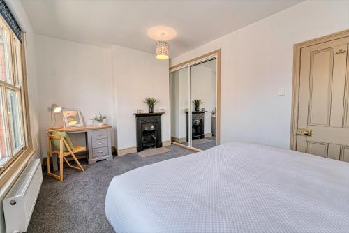 伍斯特Guest Homes - Upper Tything Studio的一间卧室配有一张床、一张书桌和一个窗户。