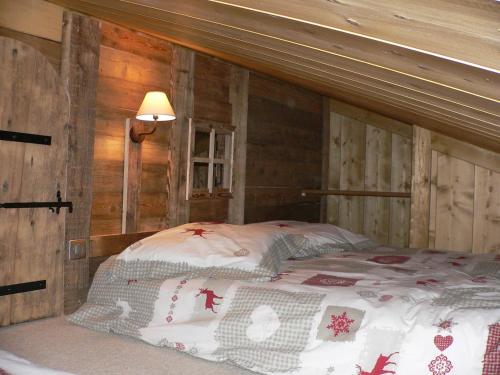 梅杰夫Petit chalet individuel de caractère的木墙客房的一张床位
