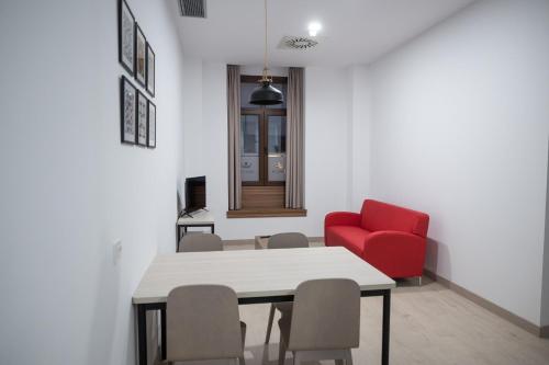 莱昂PALACIO REAL HOSTEL的一间带桌子和红色椅子的用餐室