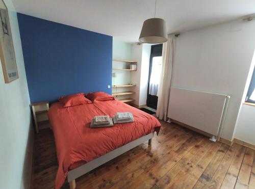 CressensacLe Cactus Orange Chambre d'hôte entrée indépendante的一间卧室配有一张红色的床和蓝色的墙壁