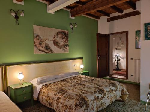费拉拉德丽特早餐加住宿酒店的一间卧室设有一张大床和绿色的墙壁