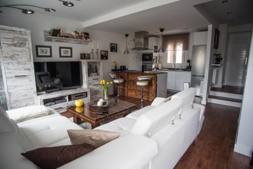 阿维拉EL PATIO DE MI CASA的一间带白色家具的客厅和厨房