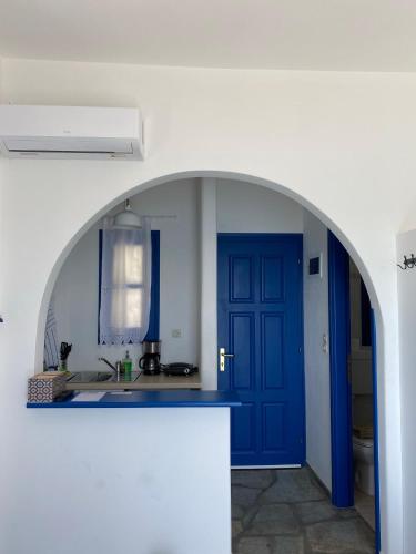 德里奥斯Cavos Studio by the sea (West)的厨房设有蓝色门和水槽