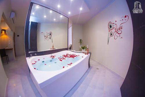 圣克鲁斯HOTEL OSHO的大型浴室设有鲜花浴缸。