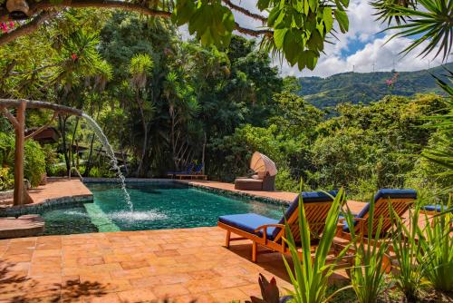 圣何塞Exclusive Hotel Don Ernesto By La Chimba的一个带两把椅子的游泳池和一个喷泉