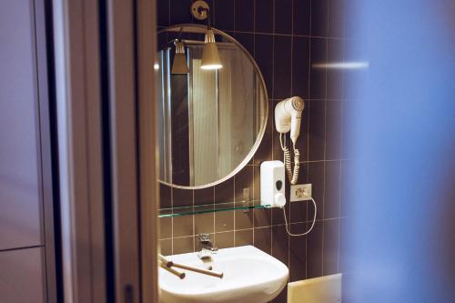 锡拉库扎LoL锡拉库扎旅馆的一间带水槽和镜子的浴室以及一部电话