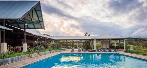 巴利托Sands Beach Simbithi Eco Estate Luxury Villa的一个带椅子的游泳池以及一座房子