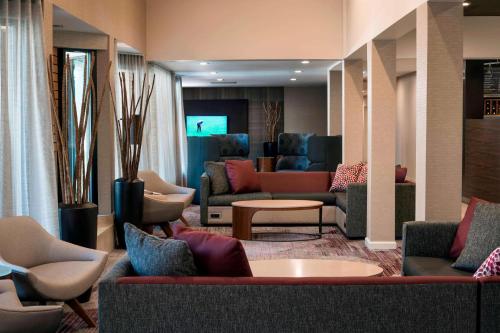 托伦斯洛杉矶托伦斯/南海湾万怡酒店的大堂配有沙发、椅子和电视。