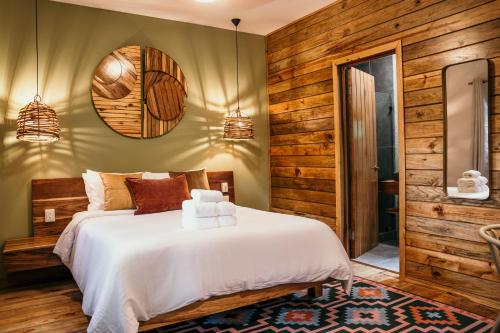 博卡斯德尔托罗Palmar Beach Lodge的卧室设有白色的床和木墙