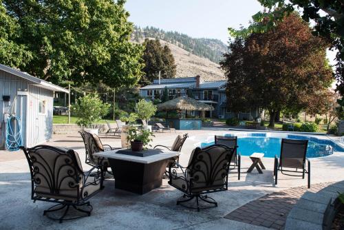 CawstonSimilkameen Wild Resort & Winery Retreat的一个带椅子和桌子的庭院,毗邻一个游泳池