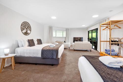 陶波Acacia Heights - Garden Cottage - Taupo的一间带两张床的卧室和一间客厅