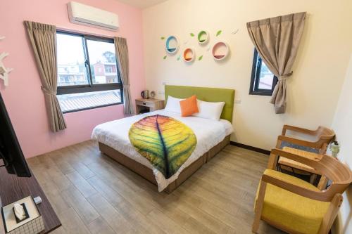 金宁乡八八小屋二馆的一间卧室配有一张带彩色毯子的床