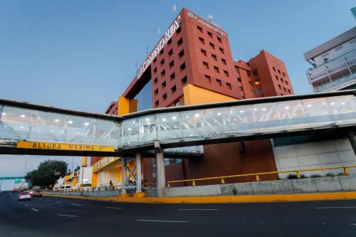 墨西哥城卡米诺皇家机场酒店的一座建筑物前的街道上的桥梁